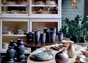 An decorative ceramic set in the interior home. Showcase of handmade ceramic pottery in a art market.