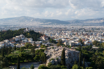 Fototapeta na wymiar Athens, Greece - Dec 20, 2019: View from the Acropolis of the Athens skyline and the Areopagus (Ares Rock), under a hazy sky caused by dust clouds