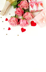 Valentine's day background. Bouquet of pink roses flowers, gift box and champagne bottle isolated on white background with copy space. Top view flat lay
