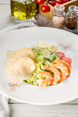 Caesar with shrimp in a white plate shot in decor
