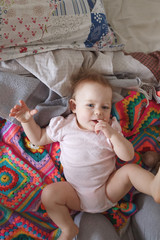 Cute smiling little baby lying on a bed, smiling