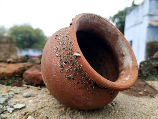 a red clay pot put on muddy place