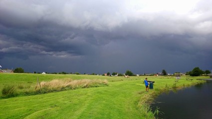 dramatic storm forming over a lush green meadow