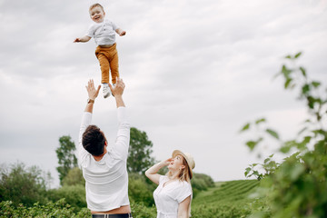 Fototapeta premium Family with cute little son. Father in a white t-shirt. Lady in a white dress