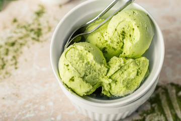 Balls of vegetarian ice cream with matcha tea in a white round plate on a marble background. horizontal image and copy space.