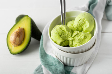 Balls of ice cream from avocado in a white porcelain bowl on a light background. Close-up image