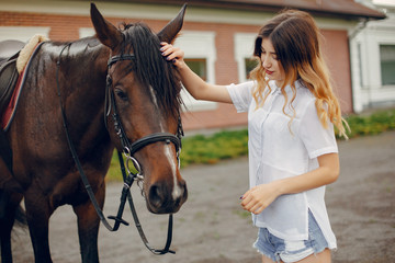 Woman standing with a horse. Lady in a white shirt