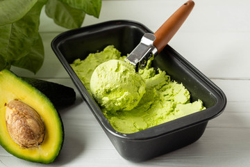 Green diet Ice cream from avocado in a metal tray on a light background. Image with horizontal orientation and