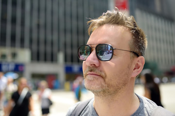 Middle age man tourist looking on Times Square on sunny summer day, downtown Manhattan, New York.