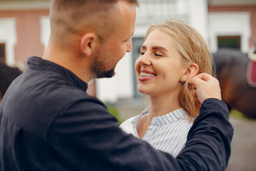 Couple in a summer rainy park. Pair standing with a horse. Girl in a white dress
