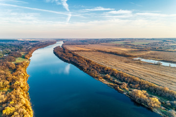 Bend of a large and wide river. Plowed fields along the riverbank.