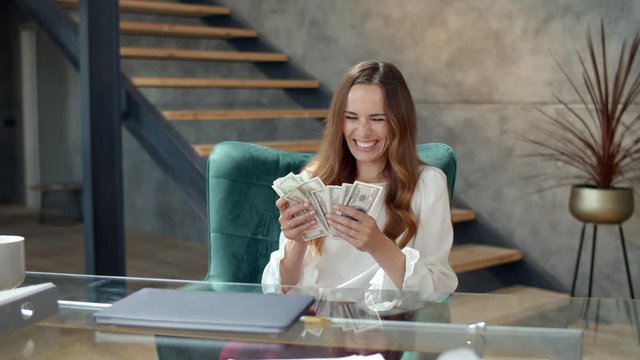 Happy woman throwing bundle of money away. Business woman counting money.