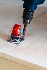 Fixing castor wheel to the wooden plywood, furniture making.