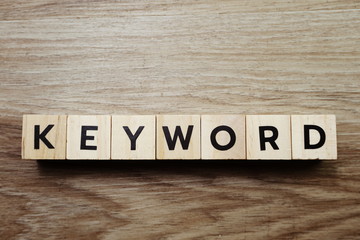 Fototapeta premium Słowo kluczowe litera alfabetu na drewnianym tle