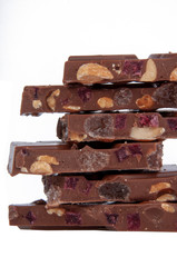 milk chocolate with nuts and berries brocken isolated on the white
