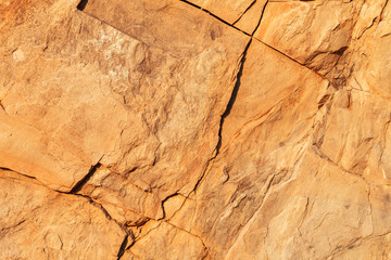 Closeup natural stone texture. Abstract nature rock background. Beige stone wall with cracks.