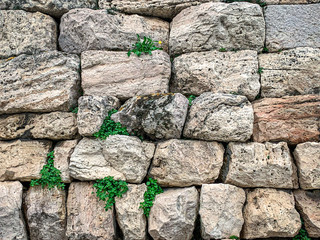 Ancient stone wall made of large limestones in Athens, Attica region in Greece. Huge antique blocks of stone piled up to form a wall. Photo.