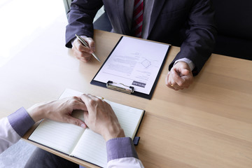 Interview employee talking about resume and job description with the job seeker sitting in front