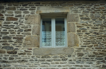 White wooden window on old house stone wall
