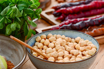 A lot of hazelnuts in wooden bowl with a spoon on wooden background. Fruit, honey and tea. Traditional Georgian cuisine