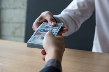 The businessman receiving bribe money from another businessman at the office