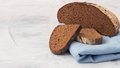 freshly baked sliced rye bread on gray kitchen table, close up, copy spase, horisontal orientation.