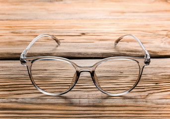 Stylish eyeglasses on wooden table