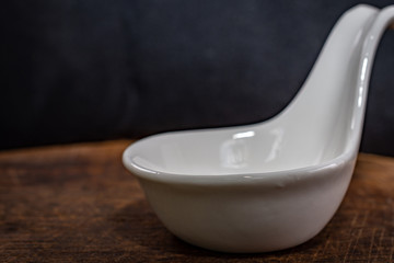 Closeup spoon placed on the floor of an old wooden chopping board with warm light in the kitchen