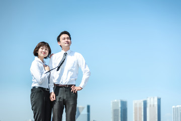 腰に手を当ててポーズをとる男性と女性（ビジネスイメージ）