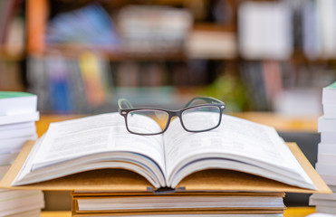 Eyeglasses lies on open book in a library