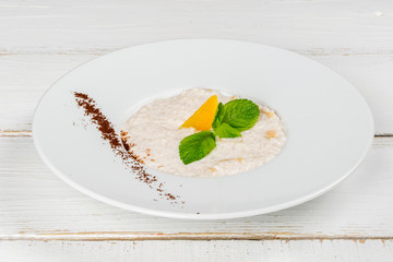 Boiled oatmeal with mango decorated with mint leaves