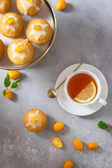 Lemon muffins and cup of tea for breakfast. Top view, copy space. Cafe, bakery, confectioenery concept.