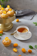 Delicious freshly baked homemade lemon muffins with a cup of tea on the table. Side view, copy space. Bakery, confectionery, cafe concept