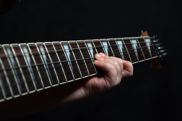 Children's hand close up learning guitar playing