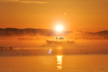 fishermen start the day with work and enormous views in a mystical lake