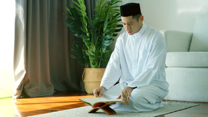 Portrait of an Asian Muslim man woman reciting Surah Al-Fatiha passage of the Qur'an in a single act of Sujud called a Sajdah or prostration in a daily prayer at home