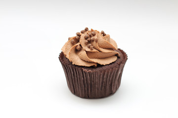 Isolated chocolate cupcake with cream top and crispy topping on a white background