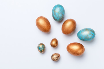 Blue and golden modern easter eggs on a white background. Top view. Isolated.
