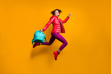 Fototapeta na wymiar Full size photo of cheerful college student girl jump run lesson hold blue rucksack enjoy wear boots purple stylish trendy bright shine trousers pants isolated yellow color background