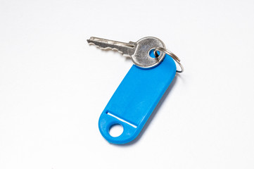 key with a blue tag on a white background, top view