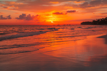 Fototapeta na wymiar Bright orange sunrise over Atlantic Ocean. Bavaro beach, Punta Cana