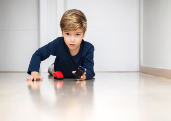 Cute kid playing with toys on the floor at home.