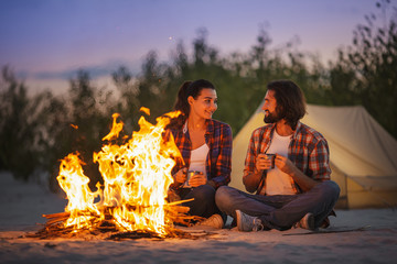 Tourist Couple Camping Near Campfire Outdoors on the Nature