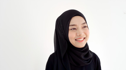 Close Up Portrait of a Young Asian Muslim Woman dressing in the traditional Hijab looking at camera smiling confident on a white background