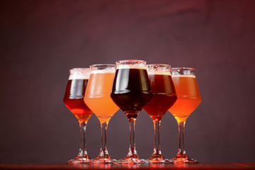 Three glasses with different beer on wooden table in a bar. Food photography concept, with copy space