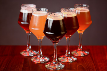 Three glasses with different beer on wooden table in a bar. Food photography concept, with copy space