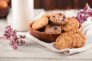 Chocolate chip cookies with milk on burlap and rustic wooden table