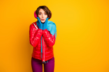 Photo of funny charming lady sending air kisses holding hands on cheekbones young millennial wear casual red overcoat blue gloves violet trousers isolated yellow color background