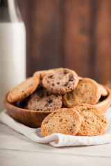 Chocolate chip cookies with milk on burlap and rustic wooden table