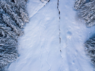 Aerial view of freeride ski traces in powder snow. Concept of action sports in backcountry mountaineering.